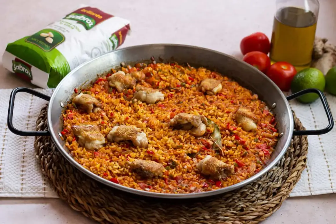 Paella de arroz con alitas de pollo, un plato lleno de sabor y color, listo para compartir.