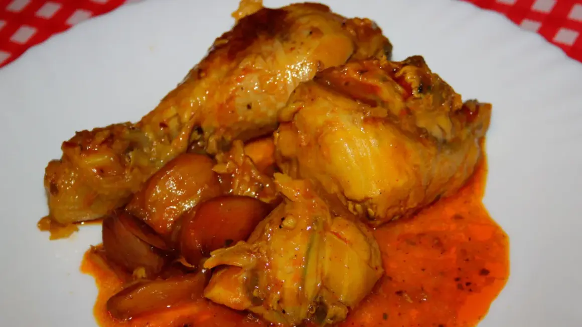 Sabroso pavo en salsa con cebollas, bañado en una rica y anaranjada salsa.