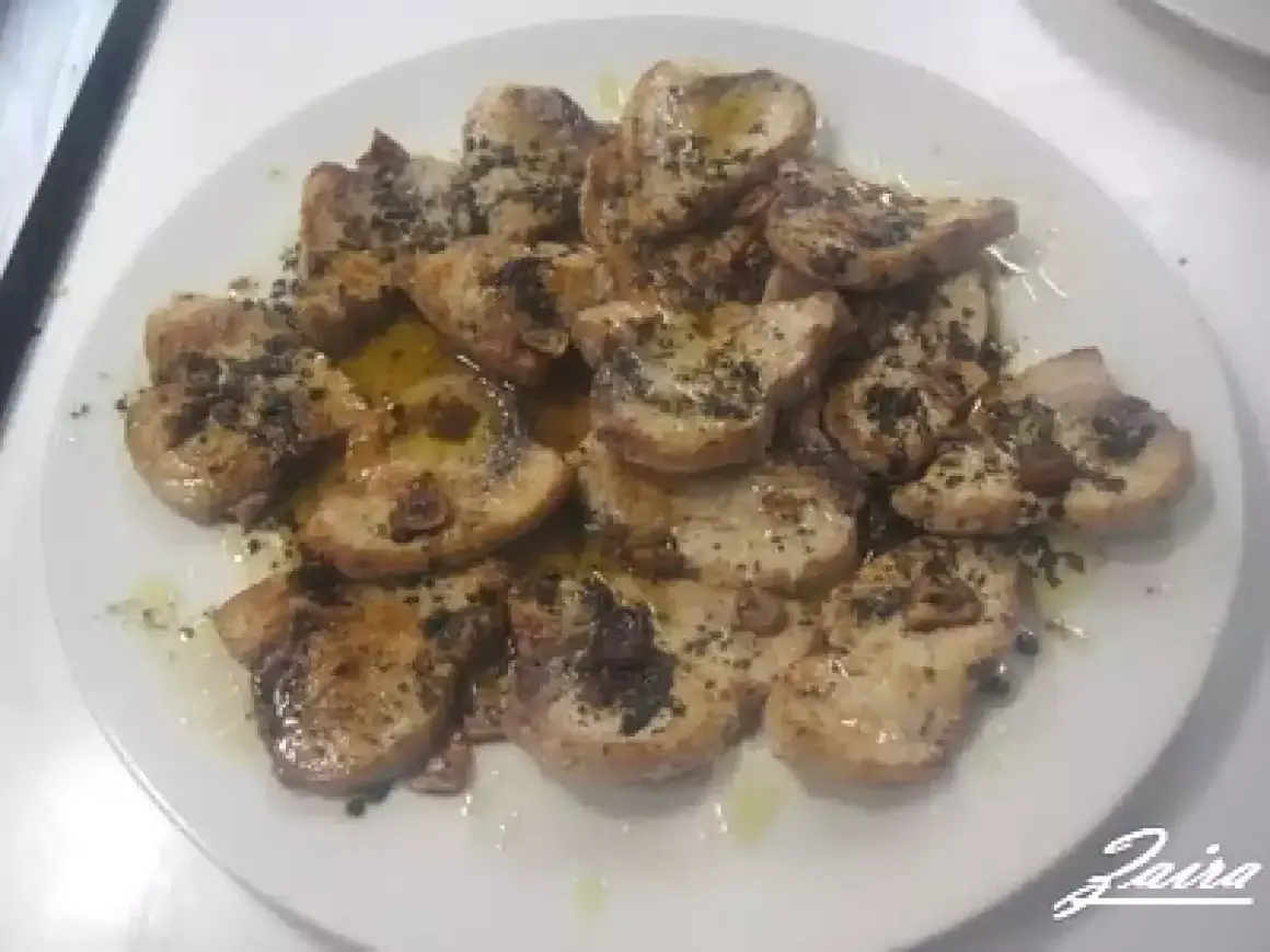 Delicioso emperador a la plancha, cortado en rodajas y servido con aceite de oliva y hierbas.