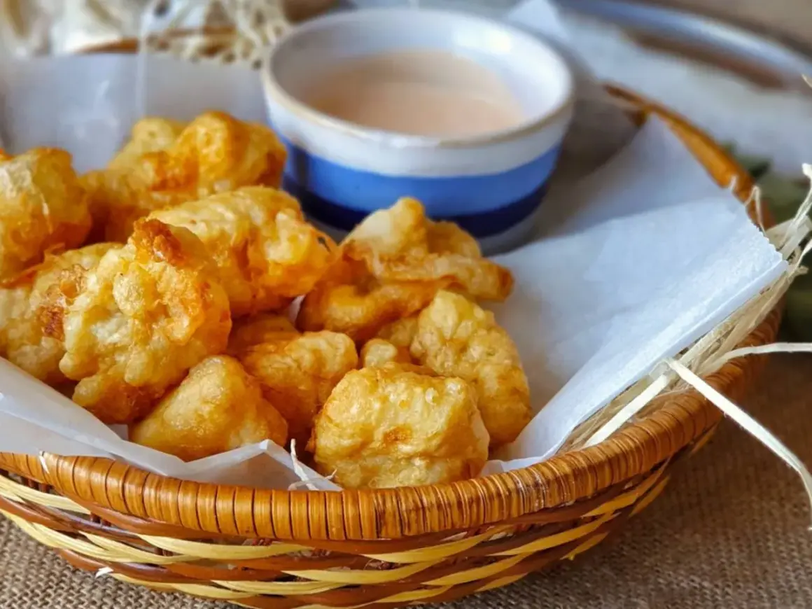 Fritos de rape crujientes y jugosos en una cesta con salsa.