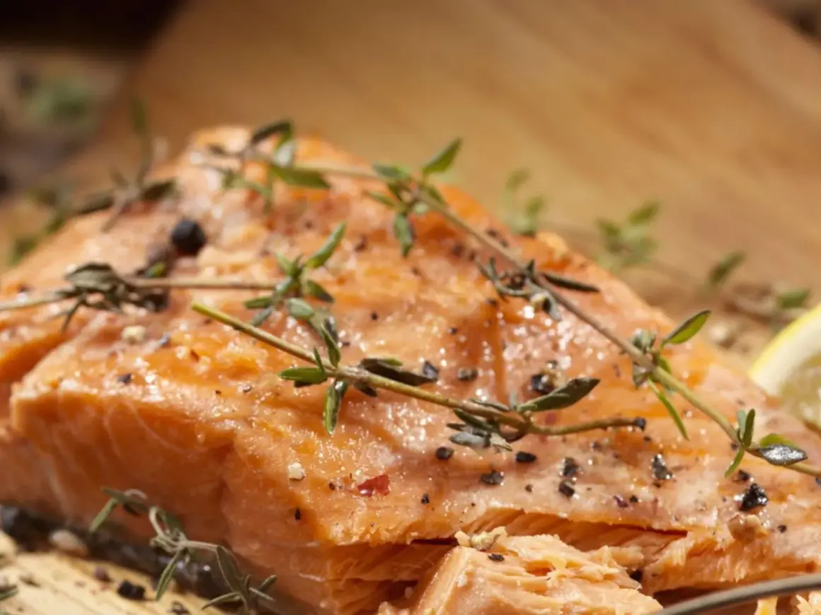 Delicioso salmón al horno, jugoso y dorado, con hierbas frescas y pimienta negra.