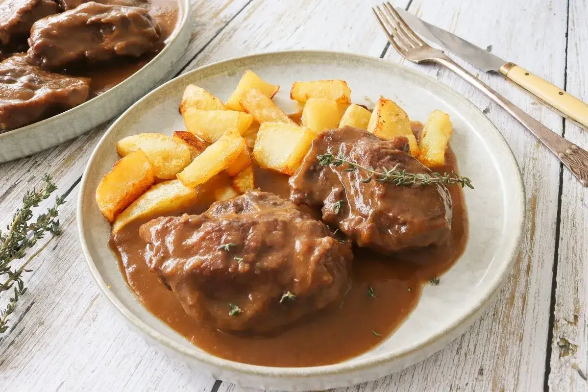 Carrilleras de ternera estofadas en salsa con patatas r&uacute;sticas. Un plato reconfortante y delicioso.