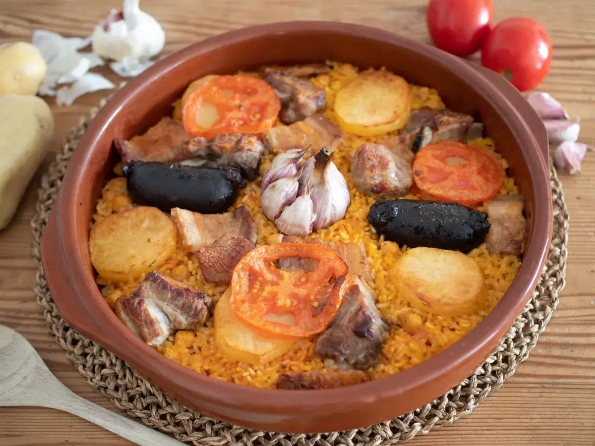 Un delicioso arroz al horno en cazuela de barro, con patatas, tomates, carne y morcilla.