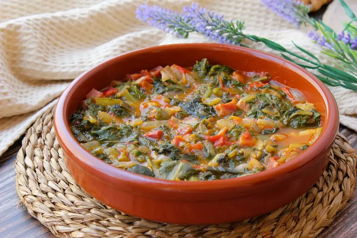 Plato de acelgas guisadas con tomate y cebolla, ideal para recetas con acelgas saludables y deliciosas.