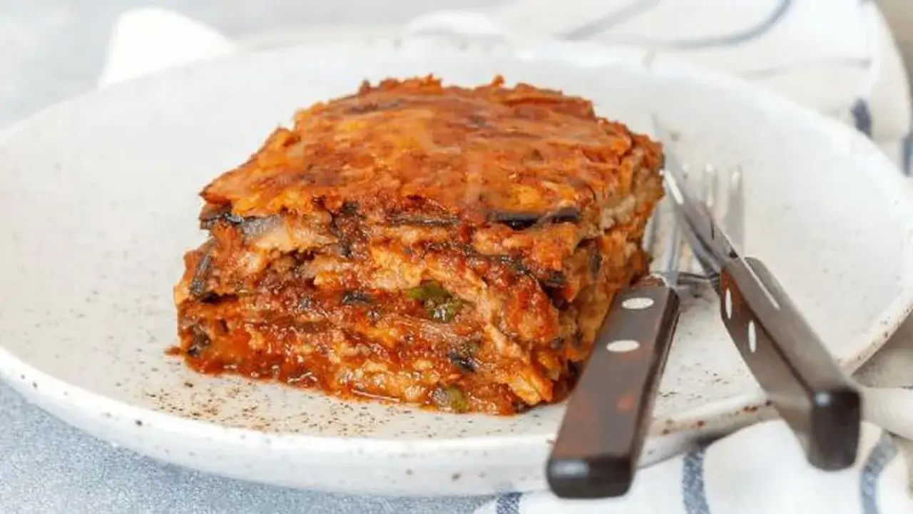 Un delicioso pastel de berenjenas, con capas de berenjena, salsa de tomate y queso, listo para ser disfrutado.