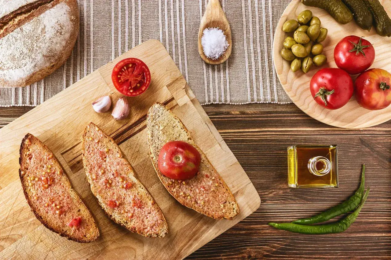 Pan tostado con tomate rallado, ajo, aceite de oliva y sal, listo para preparar un delicioso pa amb oli.