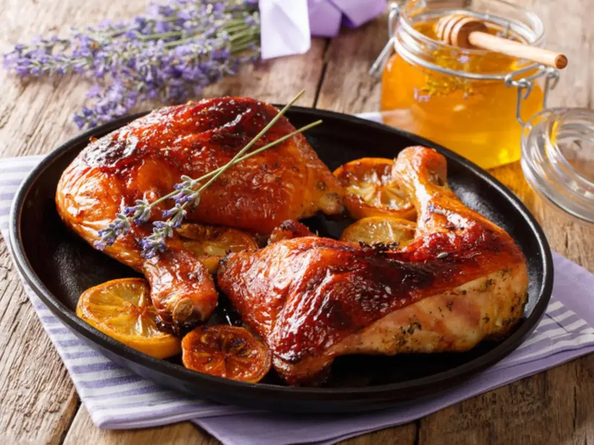 Jamoncitos de pollo dorados con limón y miel, decorados con lavanda.