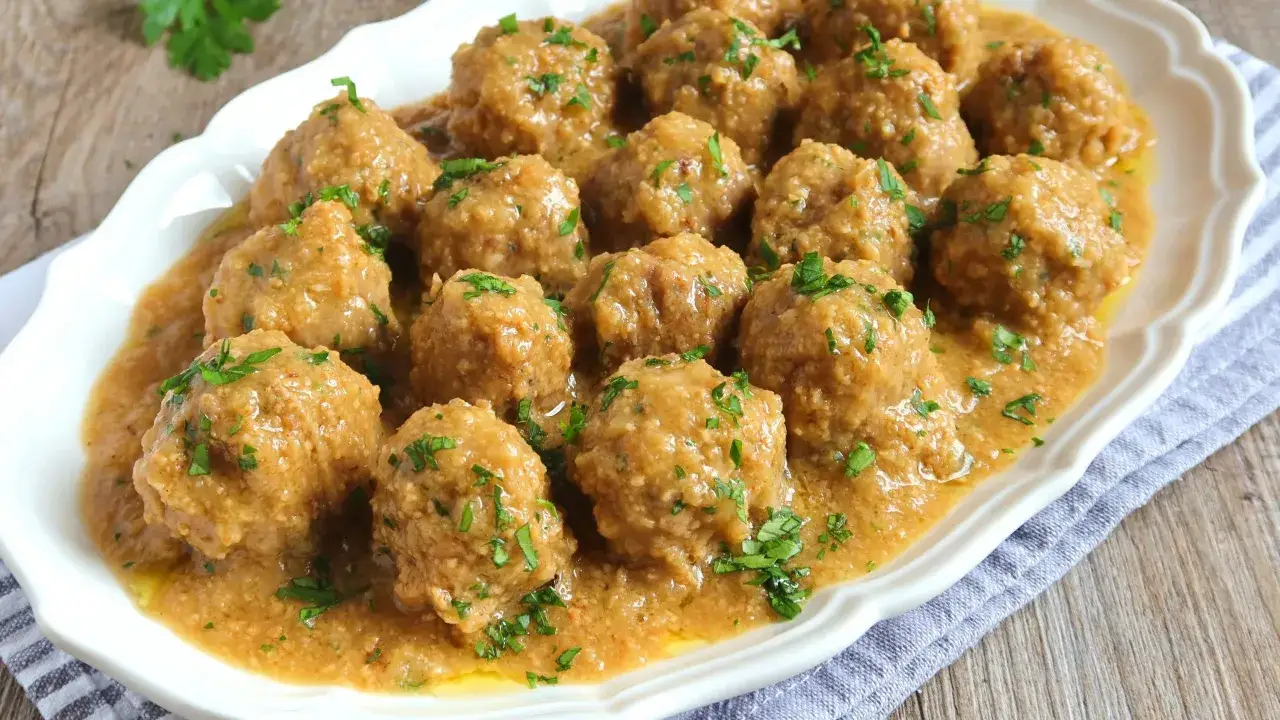 Albondigas en salsa de almendras, un plato casero y reconfortante, adornado con perejil fresco.