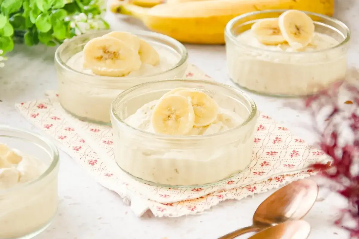 Deliciosos postres con platano en vasitos de cristal, decorados con rodajas de la fruta.