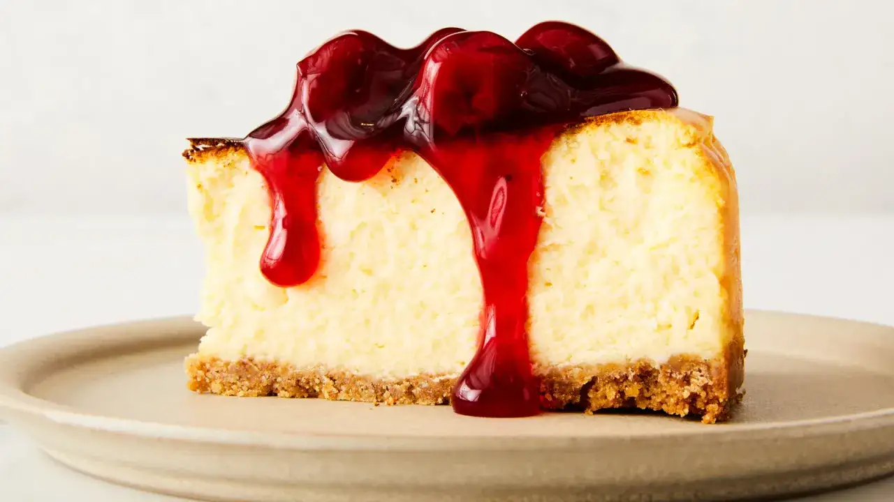 Tarta de queso en freidora de aire, cubierta con salsa de cereza roja brillante.