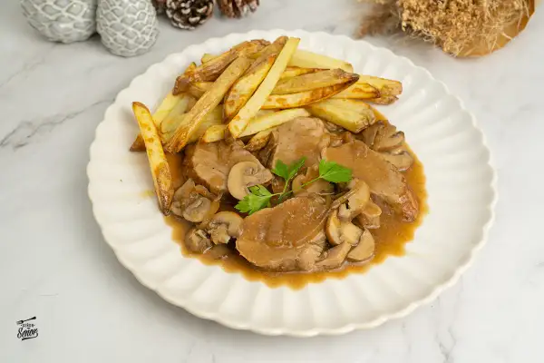 Solomillo en salsa de la abuela con champiñones y patatas fritas. Un plato casero que evoca recuerdos.