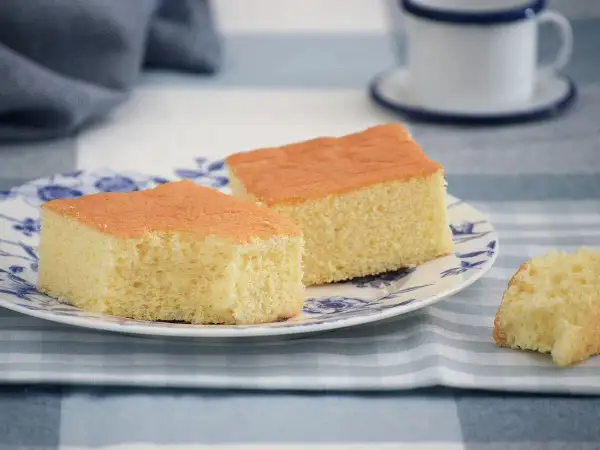 Dos porciones de pa de pessic esponjoso y dorado en un plato con diseño azul.