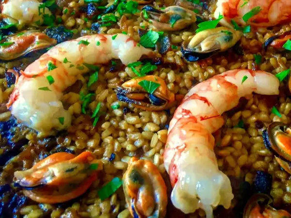 Arroz con gambas y mejillones, un plato lleno de sabor y color, con el arroz dorado y los mariscos frescos.