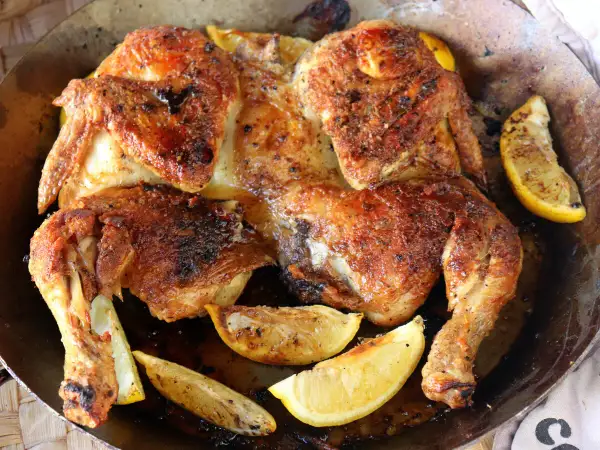Pollo asado dorado y jugoso, perfecto para desmenuzar y usar en deliciosas recetas. Acompañado de gajos de limón asado.