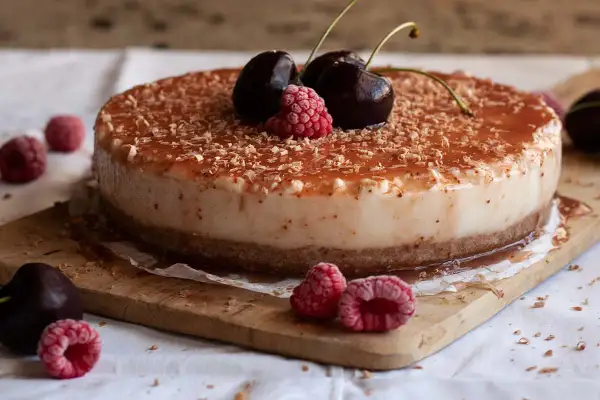 Tarta de queso con leche condensada, cubierta de frutos rojos y virutas de chocolate. ¡Un postre irresistible!